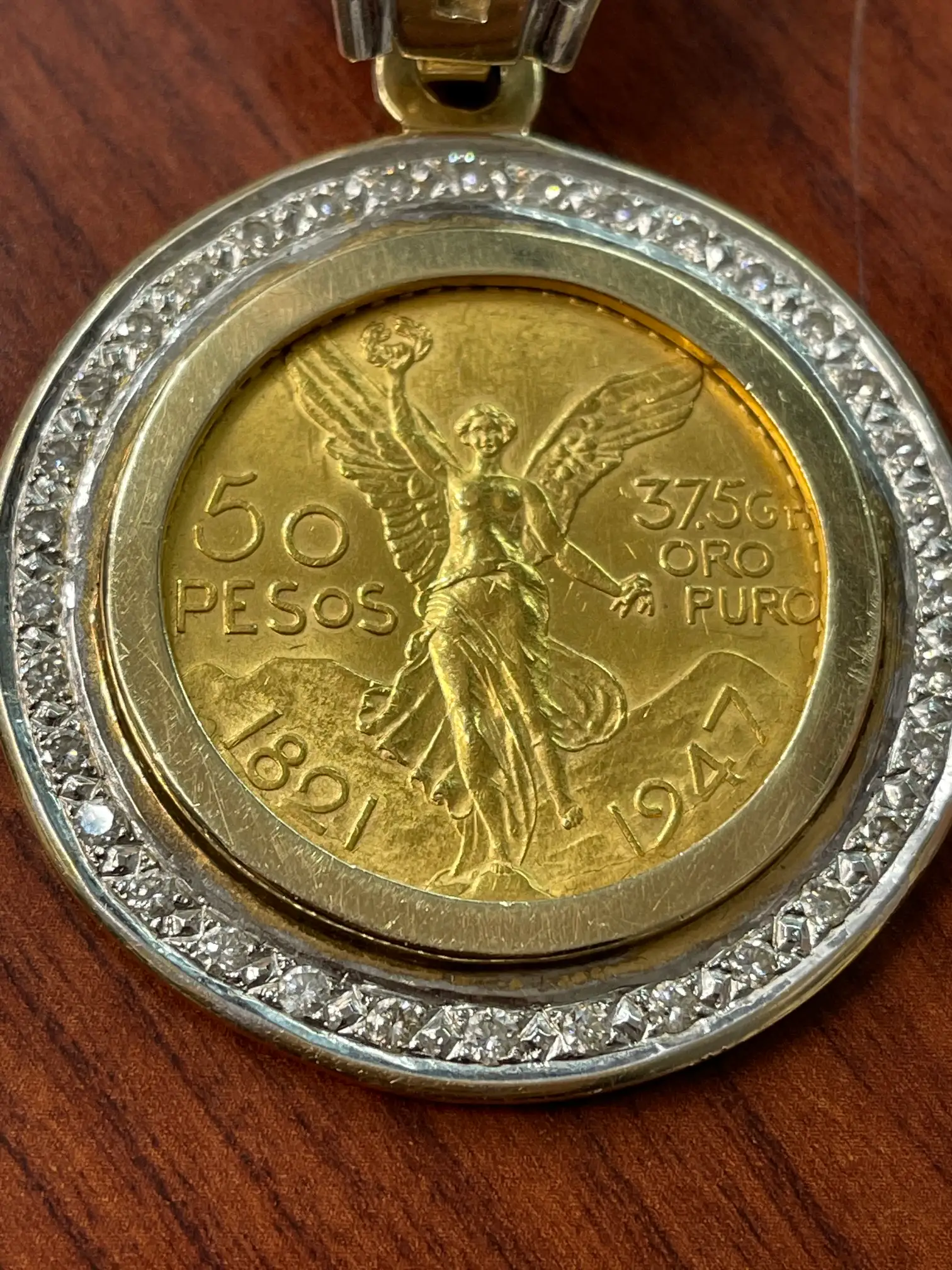 A Mexican 50 peso gold coin set in a diamond bezel pendant, an estate piece we purchased