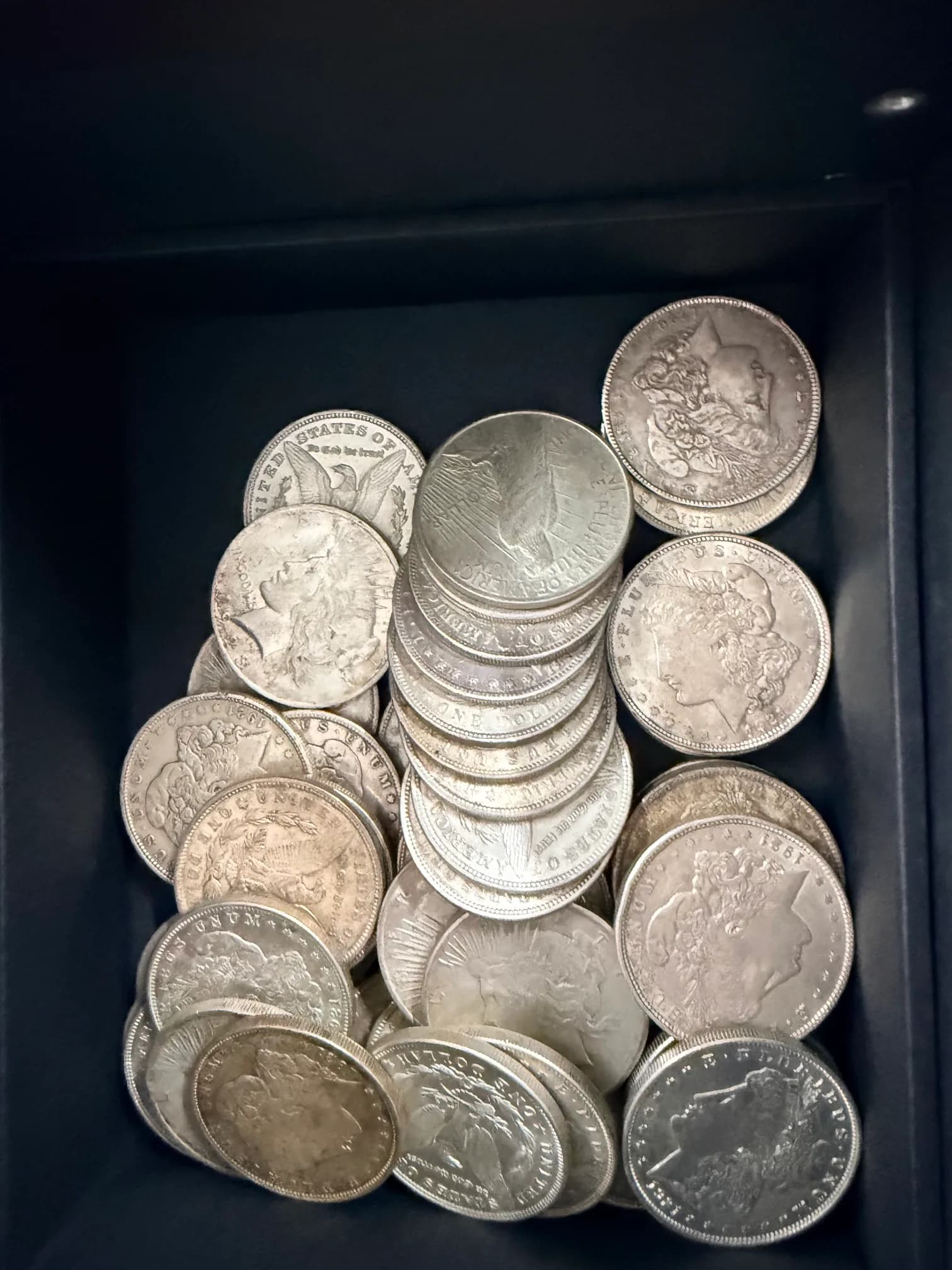A tray of Morgan and Peace silver dollars in the shop safe
